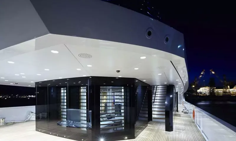 Suerte: Lit deck at night with a glass enclosed room and stairs beside it