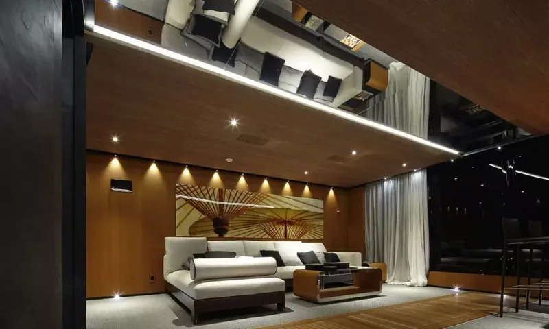 Suerte: Dimly lit lounge with a white sofa, wood walls and mirrored ceiling strip