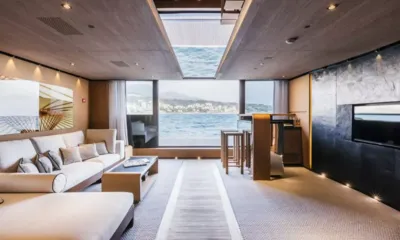 Suerte: Lounge with cream sofas, a bar with stools and a large window to the sea