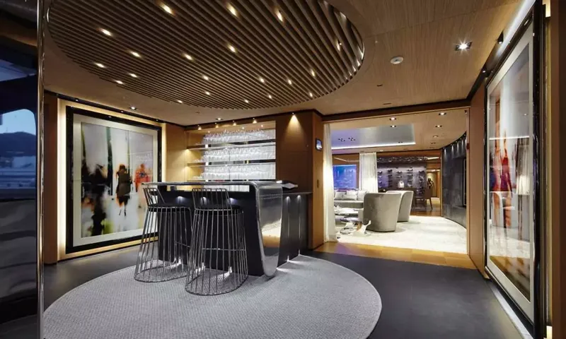 Suerte: Bar with wire stools and glass shelves leading to a lounge area