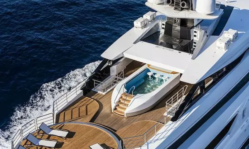 Suerte: Elevated view of an aft deck with a jacuzzi pool, sun loungers and teak decking under way