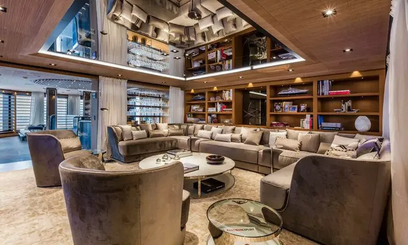 Suerte: Lounge with large curved sofa, velvet armchairs, bookshelves and mirrored ceiling