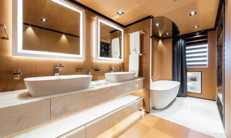 Suerte: Bathroom with twin basins, lit mirrors, marble counter and freestanding bathtub