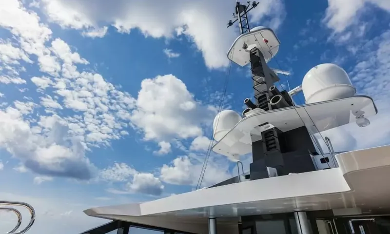 Suerte: Radar mast with white domes against a blue sky with clouds
