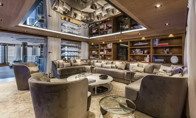 Suerte: Lounge with large curved sofa, velvet armchairs, bookshelves and mirrored ceiling