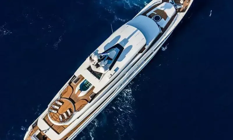 Suerte: Overhead view of a long white yacht on dark blue sea with teak decks