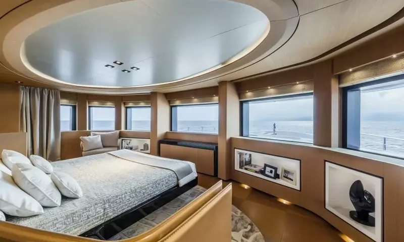 Suerte: Cabin with double bed, curved wall of large windows facing the sea and display niches