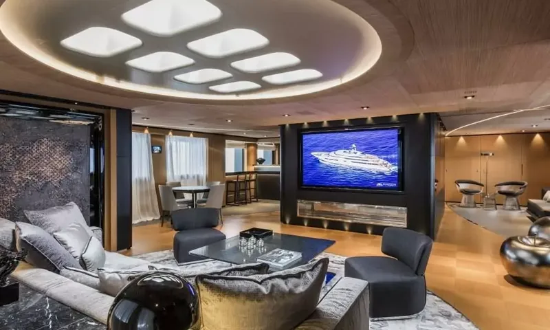 Suerte: Lounge with sofas, armchairs, glass coffee table and wall screen, bar and game table beyond