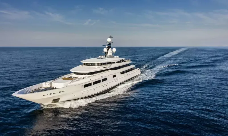 Suerte: Yacht cruising at speed with a long wake across deep blue sea