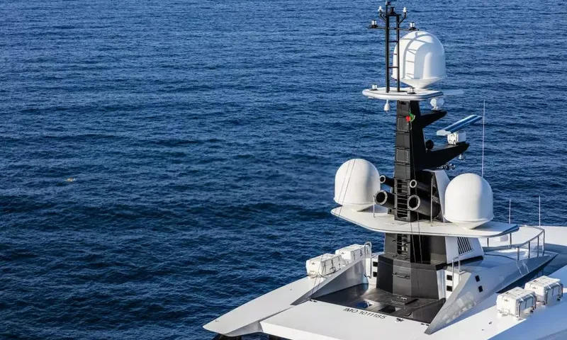 Suerte: Dark mast with white radar domes and antennas above the sea