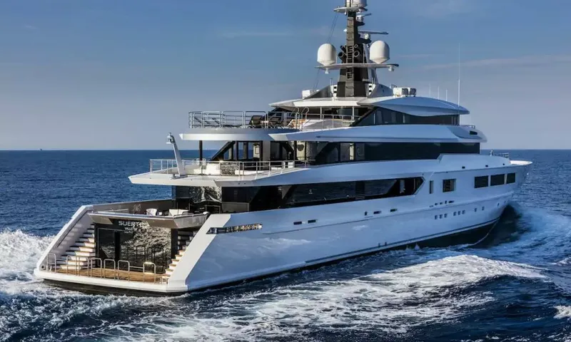 Suerte: Stern quarter view of the yacht under way with staircases and open aft decks