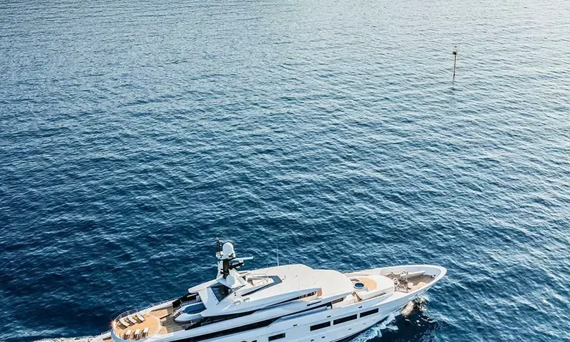 Suerte: Yacht seen from above at the bottom of the frame on open blue sea