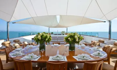Suri: Mesa redonda externa posta com flores brancas sob um toldo com vista para o mar