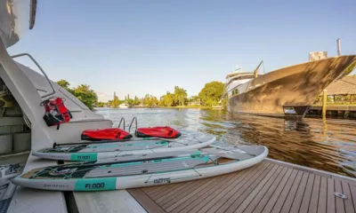 Sweet Emocean: Duas pranchas de paddle e dois scooters subaquáticos na plataforma de popa de teca ao lado de um canal