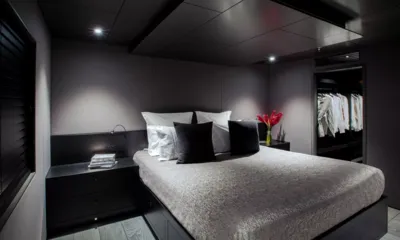 The Beast: Dark grey double cabin with bedside tables, red flowers and an open wardrobe