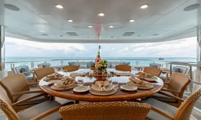 Zoom Zoom Zoom: Round table set for lunch with wicker chairs on a shaded deck facing the sea