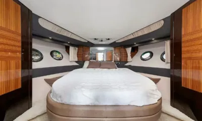Harmony: Cabine com cama grande branca, vigias redondas e guarda-roupas de madeira brilhante