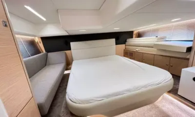 Bavaria Fly: Cabin with a double bed, grey sofa, wood cabinets and blinds on the windows