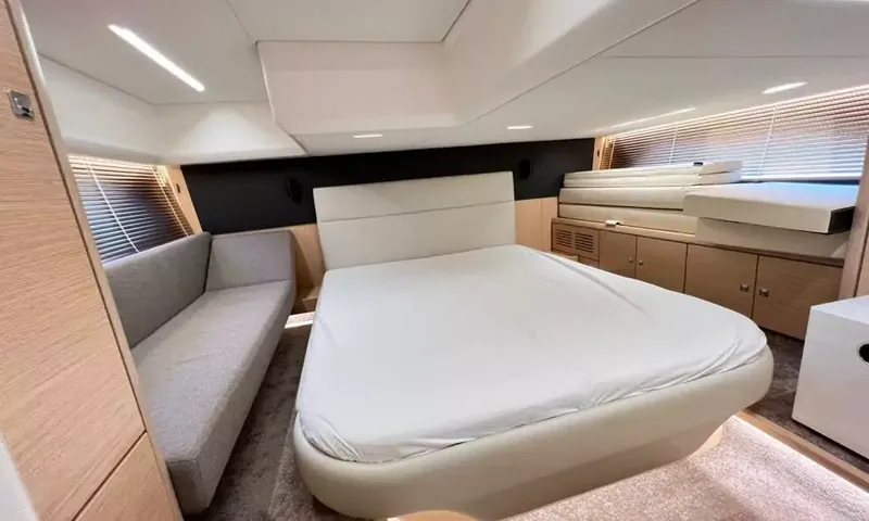 Bavaria Fly: Cabin with a double bed, grey sofa, wood cabinets and blinds on the windows