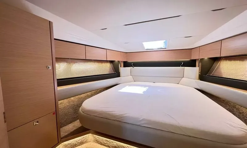 Bavaria Fly: Forward cabin with a large bed, overhead hatch and wood panelled walls