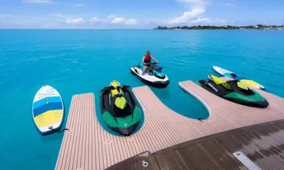 Halcyon: Jet skis e pranchas de paddle atracados em uma plataforma flutuante ao lado da popa