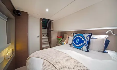 Interlude: Guest cabin with double bed, blue patterned cushion, roses and candles