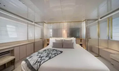 Quarantena: Cabina con letto matrimoniale, plaid a motivi, pareti bianche lucide e porte in vetro