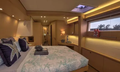 Whispers II: Cabina con letto matrimoniale, copriletto a motivi, asciugamani, osteriggio e finestra con luce calda