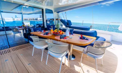 Mariah Princess III: Mesa de jantar externa posta com frutas e suco em um deck de popa sombreado junto ao mar