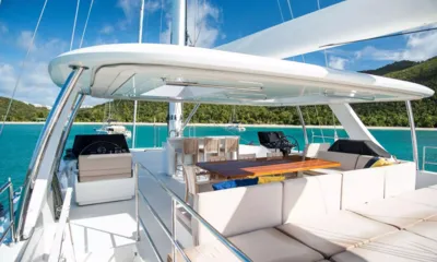 Bundalong: Flybridge with twin helms, dining table, bar stools and sunpads under a hardtop