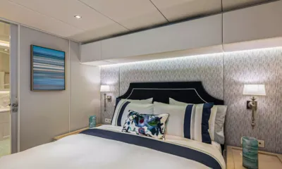 Bundalong: Cabin with double bed, navy headboard, wall lamps and artwork