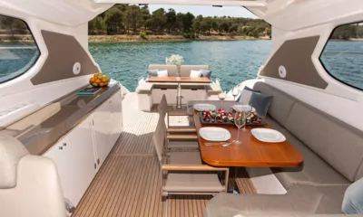 Fellow III: Pozzetto coperto con tavolo da pranzo apparecchiato, divano e un tavolo a poppa rivolto verso il mare