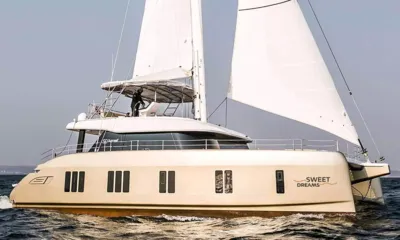 Sweet Dreams: Catamarã creme navegando com velas brancas totalmente içadas em mar agitado