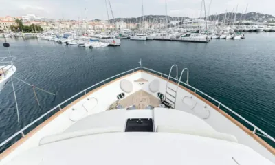 Accama Delta: Vista sobre o convés de proa e a proa em direção a uma marina cheia de veleiros e uma cidade