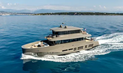 Kokonut's Wally: Yacht a motore grigio in navigazione su acque blu e calme vicino a un promontorio verde