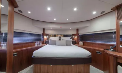 Mr Sea: Cabina con letto matrimoniale centrale, pannelli in legno e tende alle finestre su entrambi i lati