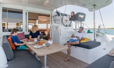 Lagoon 400: Família tomando café da manhã na mesa sombreada do convés de popa ao lado do posto de comando