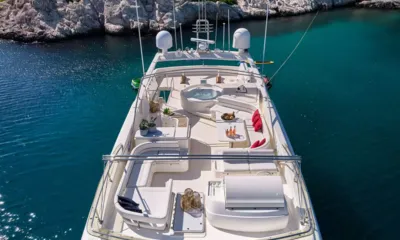 Estia Yi: Vista de cima do deck superior com jacuzzi, assentos e colchonetes de sol em uma enseada turquesa