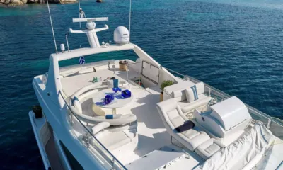 Miren: Flybridge vu du dessus avec table ronde, banquette courbe, bains de soleil et arche radar au-dessus d'une eau bleue