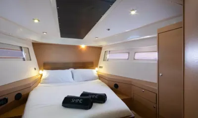 Shine III: Cabina con letto matrimoniale, asciugamani arrotolati, armadietti in legno e piccole finestre laterali