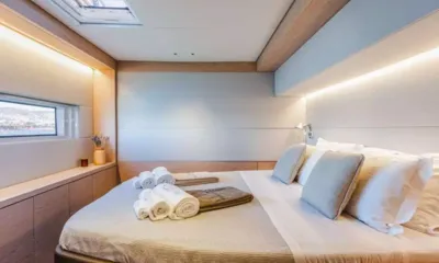 White Caps: Cabine dupla com travesseiros, toalhas dobradas na cama, janela no casco e claraboia
