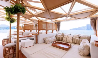 Vibe: Lounge ao ar livre com sofás estofados e banquetas de rattan com vista para o mar