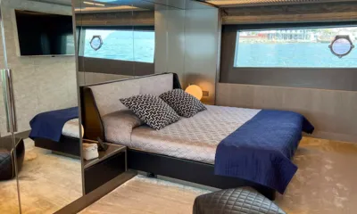 E3: Cabina con letto matrimoniale, plaid blu, armadio a specchio, TV e grande finestra con oblò