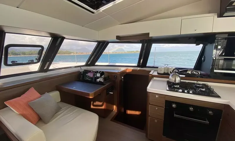 Sea Spirit 3: Cozinha com fogão a gás e forno ao lado de uma mesa de navegação e do sofá do salão