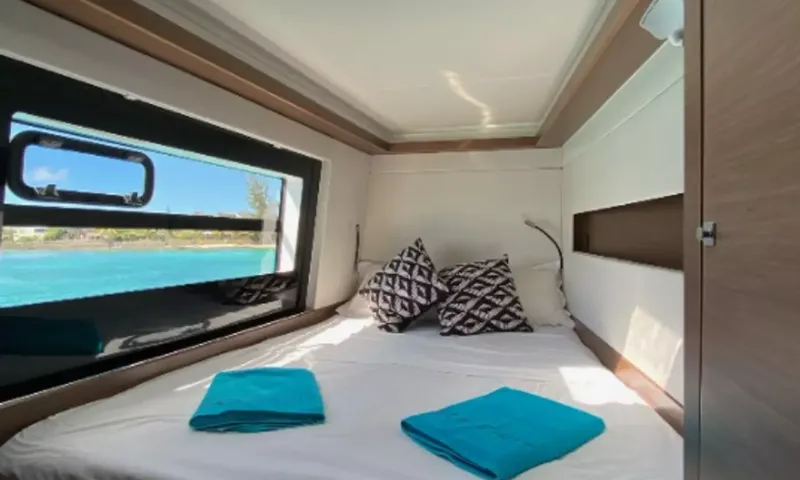 Sea Spirit 3: Cabine dupla com almofadas estampadas, toalhas turquesa e uma grande janela no casco