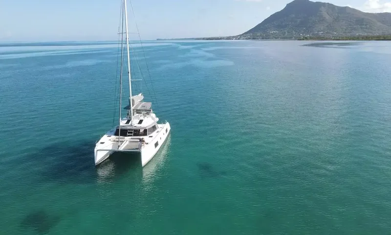 Sea Spirit 3: Catamarã ancorado em águas calmas verde azuladas com uma montanha ao longe