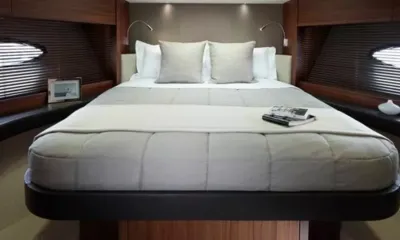 Babby Cool: Letto matrimoniale con trapunta grigia e cuscini tra pannelli in legno e oblò ovali