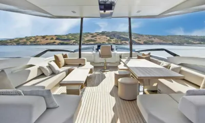 Lara: Shaded flybridge with sofas, a dining table and the helm seat facing the sea