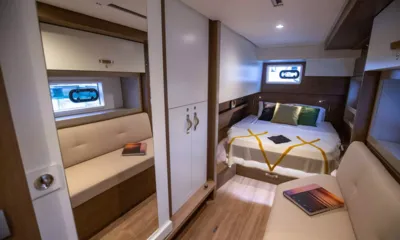 Said: Cabina ospiti con letto matrimoniale, cuscini, armadio, panca e piccoli oblò