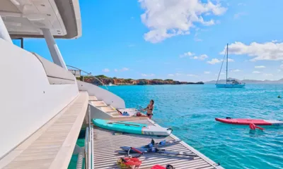 Frenchwest: Plateforme arrière avec paddleboards et skis nautiques, une femme se préparant à nager dans une baie